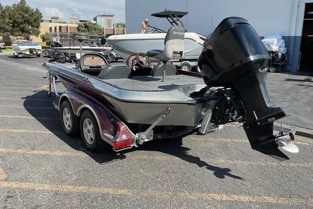 Slide: The Image of 2000 Ranger 518SVX Comanche boat with outboard motor in a parking lot. - 3
