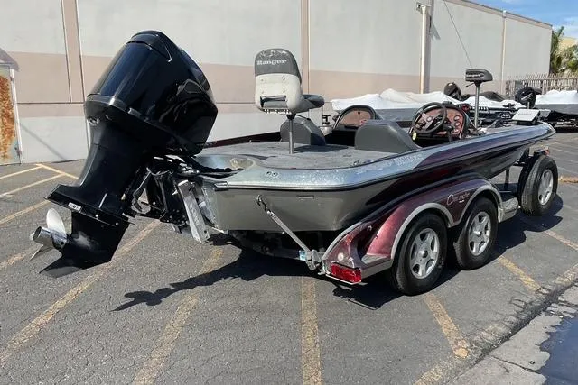 Slide: The Image of 2000 Ranger 518SVX Comanche boat with powerful outboard motor in parking lot. - 8