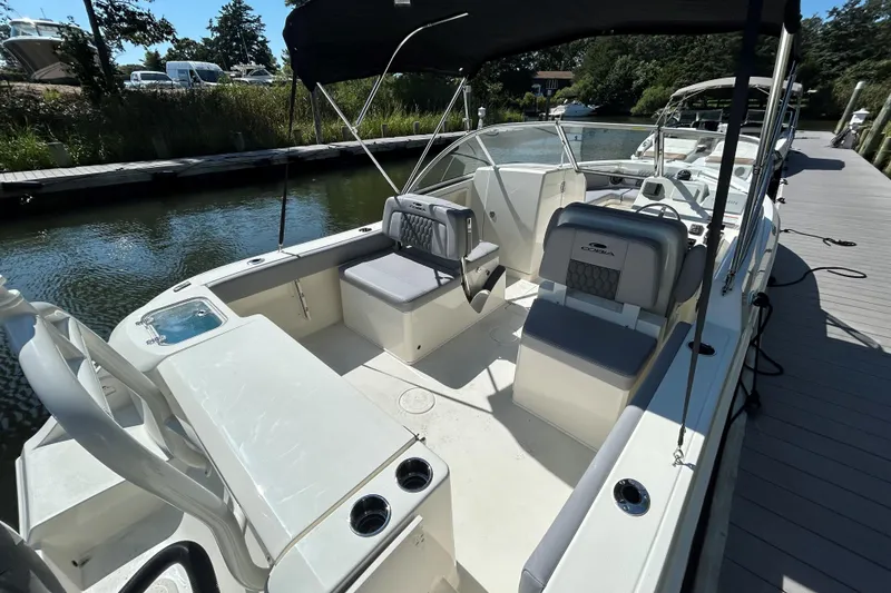 Slide: The Image of 2026 Cobia 220 Dual Console boat docked, featuring spacious seating and sleek design. - 3