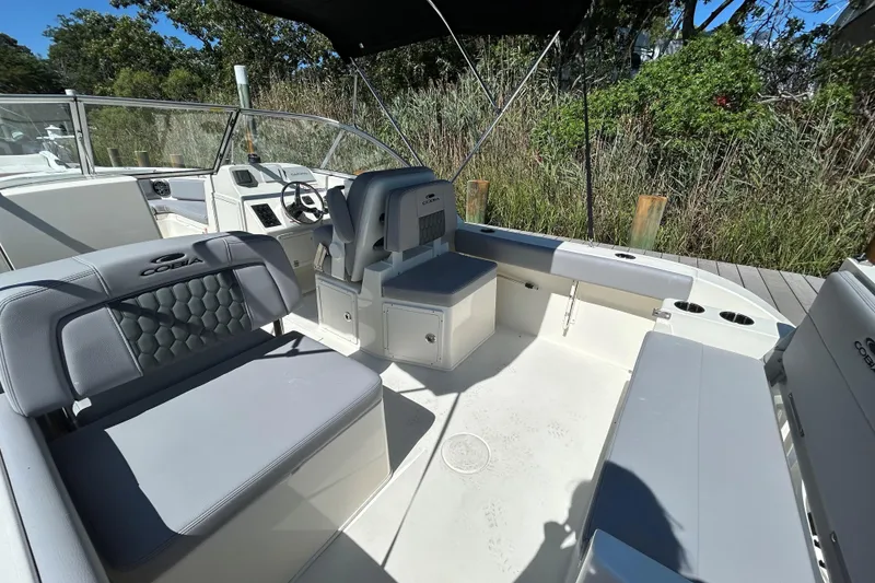 Slide: The Image of 2026 Cobia 220 Dual Console boat interior with seating and steering wheel. - 6