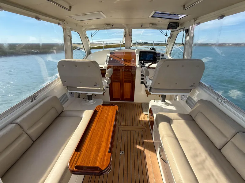 Slide: The Image of 2015 MJM 36z Downeast boat interior with plush seating and wooden accents. - 14