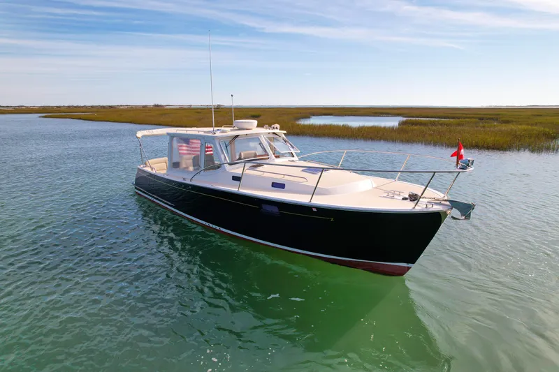 Slide: The Image of 2015 MJM 36z Downeast boat on calm water, scenic marshland background. - 2