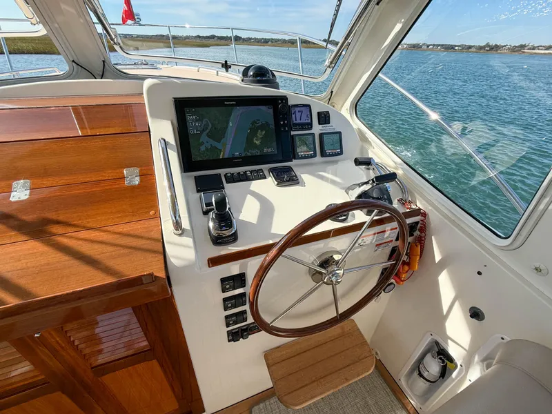 Slide: The Image of 2015 MJM 36z Downeast helm with wooden wheel and navigation display on calm waters. - 23