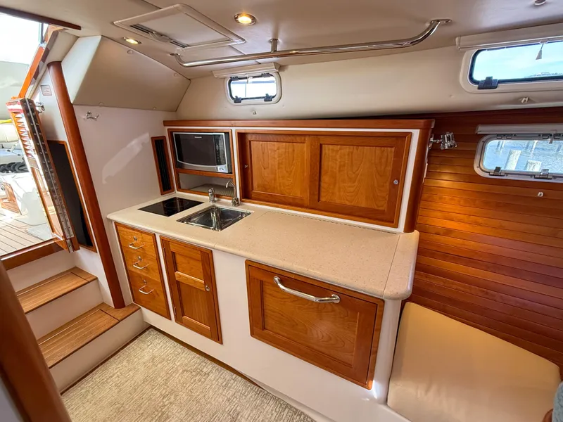 Slide: The Image of 2015 MJM 36z Downeast yacht interior with wooden cabinetry and compact kitchen area. - 32