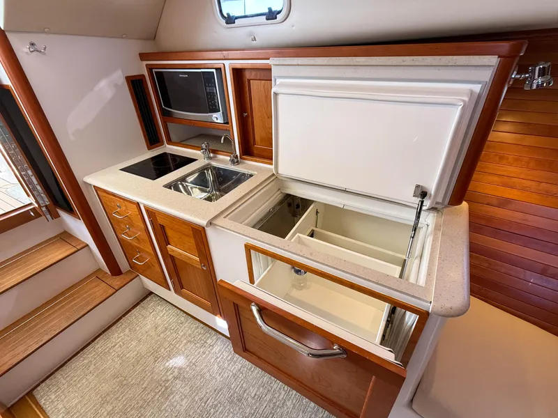 Slide: The Image of 2015 MJM 36z Downeast yacht kitchen with sink, microwave, and open fridge. - 33