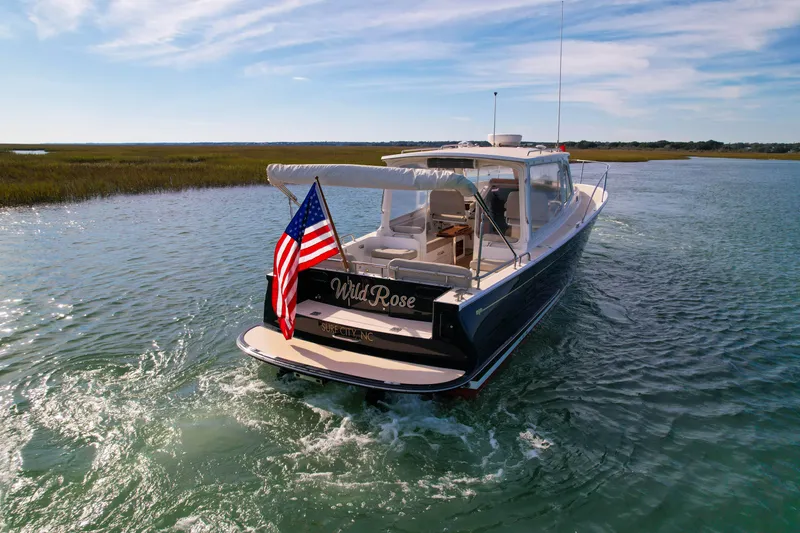 Slide: The Image of 2015 MJM 36z Downeast boat cruising on a sunny day with American flag. - 4