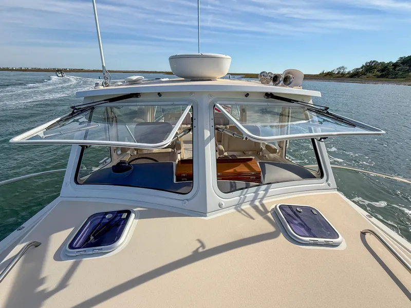 Slide: The Image of 2015 MJM 36z Downeast boat cruising on calm waters, open windows, clear sky. - 43