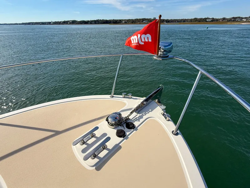 Slide: The Image of 2015 MJM 36z Downeast boat bow with red flag on calm water. - 44