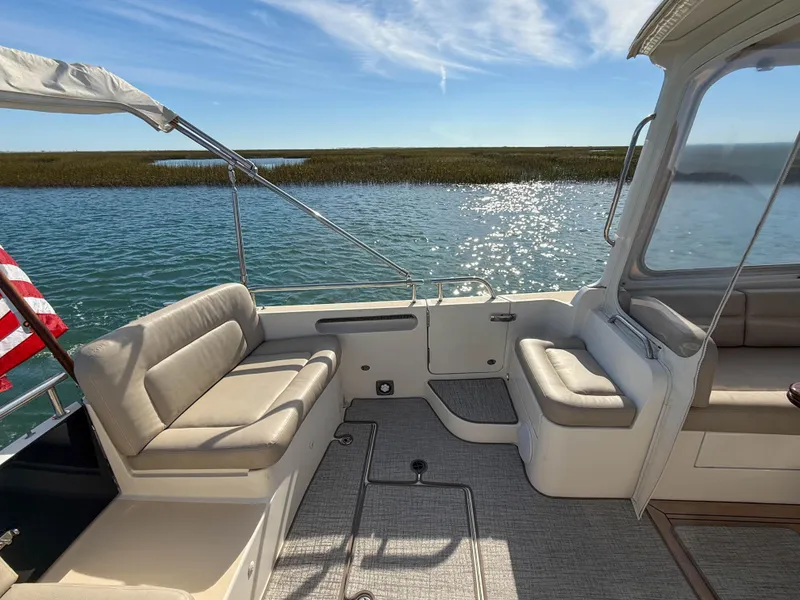 Slide: The Image of 2015 MJM 36z Downeast boat interior with seating, overlooking serene water and clear sky. - 8