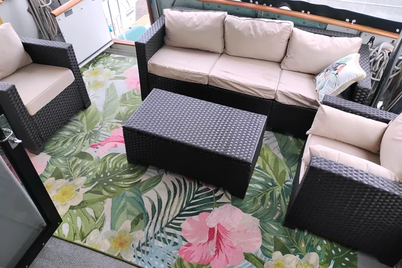Slide: The Image of Outdoor seating area on 1991 Californian 52 Cockpit Motor Yacht with floral rug and wicker furniture. - 16