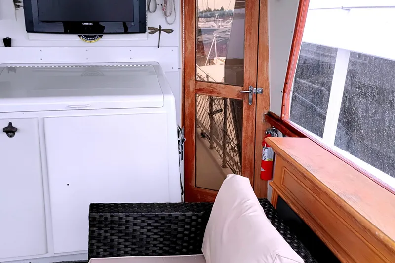 Slide: The Image of Interior of 1991 Californian 52 Cockpit Motor Yacht with TV, seating, and wooden door. - 19