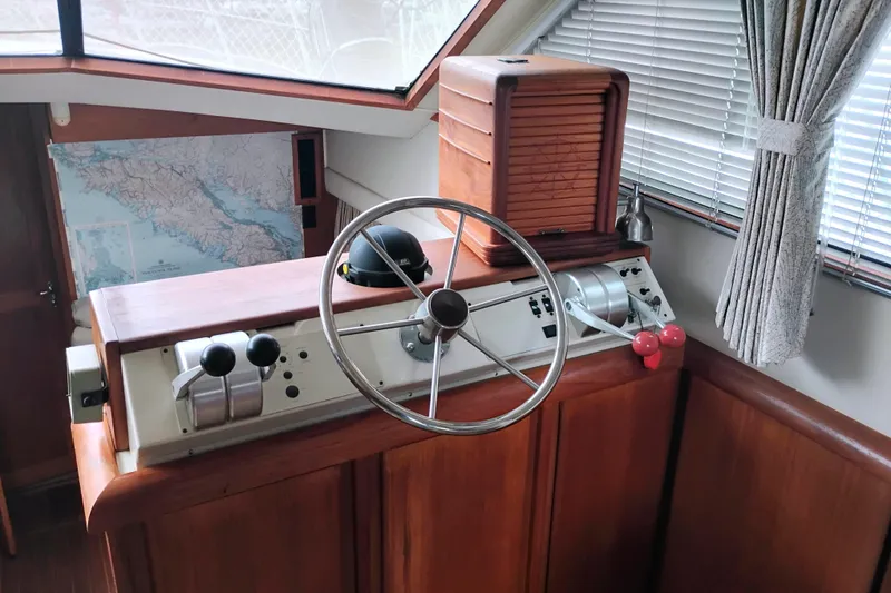 Slide: The Image of Helm of 1991 Californian 52 Cockpit Motor Yacht with steering wheel and controls. - 26