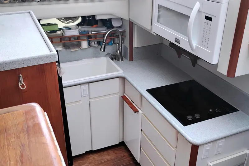 Slide: The Image of Compact kitchen in a 1991 Californian 52 Cockpit Motor Yacht with modern appliances. - 30