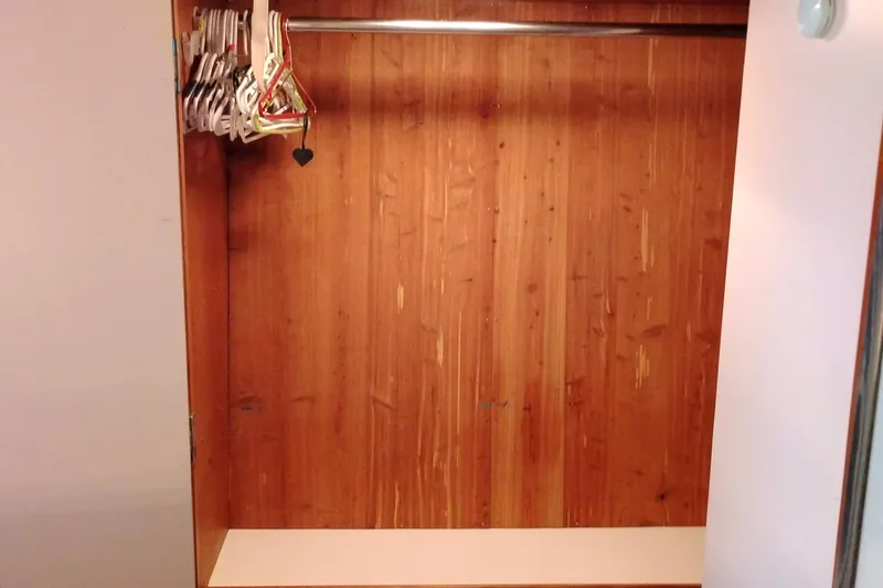 Slide: The Image of Empty wooden closet with hangers, inside a 1991 Californian 52 Cockpit Motor Yacht. - 50