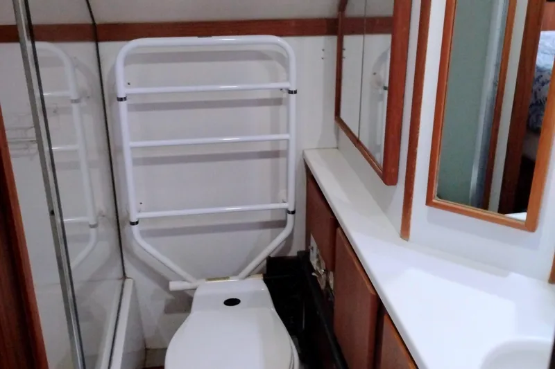 Slide: The Image of Bathroom interior of 1991 Californian 52 Cockpit Motor Yacht with toilet and mirror. - 53