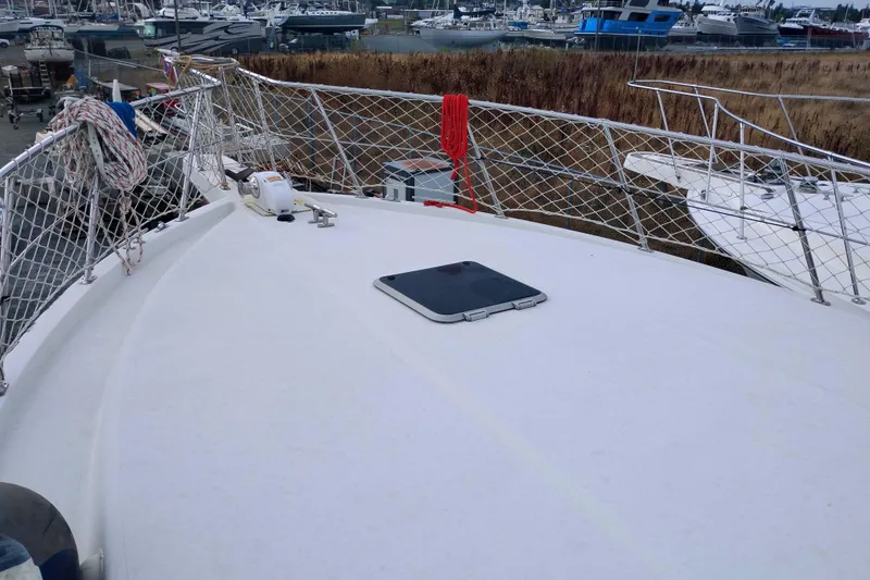 Slide: The Image of 1991 Californian 52 Cockpit Motor Yacht deck with netted railings and hatch. - 57