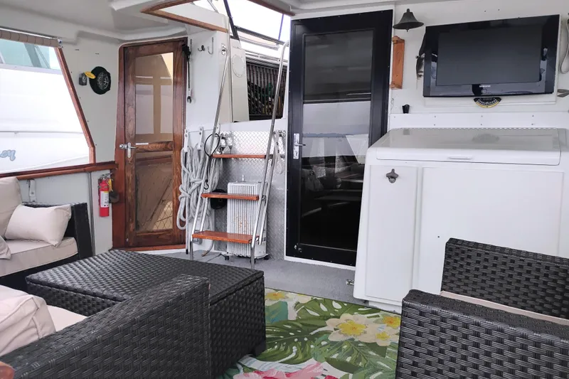 Slide: The Image of Interior of 1991 Californian 52 Cockpit Motor Yacht with seating, TV, and wooden door. - 9