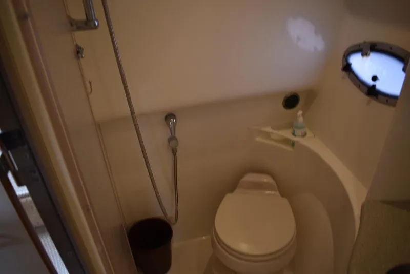 Slide: The Image of 2005 Formula 37 PC bathroom with toilet, shower, and porthole window. - 33