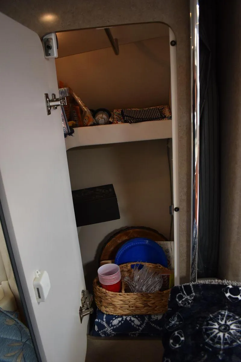 Slide: The Image of Open storage cabinet in 2005 Formula 37 PC boat with shelves and basket. - 43