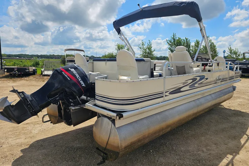 Slide: The Image of 2004 Misty Harbor 2285CF pontoon boat with Mercury outboard motor, parked on a sunny day. - 2