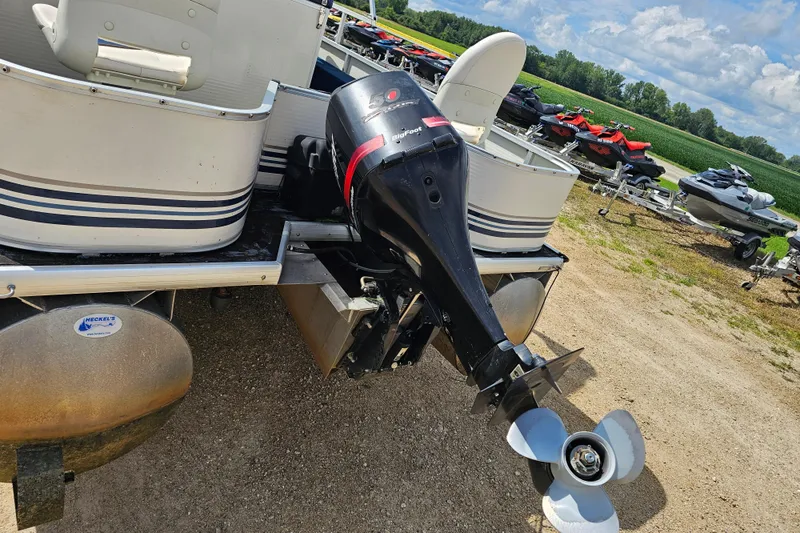 Slide: The Image of 2004 Misty Harbor 2285CF pontoon boat with outboard motor, parked on gravel lot. - 9