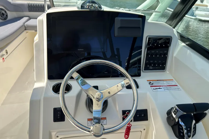 Slide: The Image of 2026 Cobia 280 Dual Console boat dashboard with steering wheel and control panel. - 12