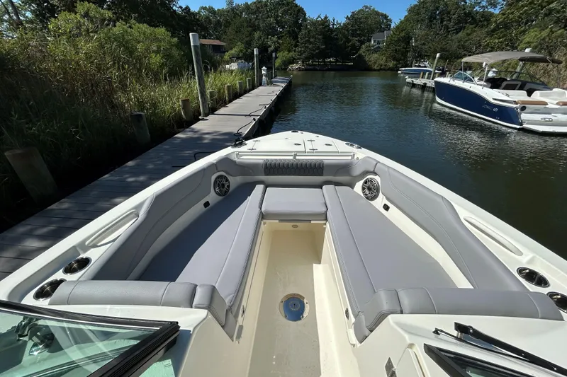 Slide: The Image of 2026 Cobia 280 Dual Console boat docked, featuring spacious seating and sleek design. - 14