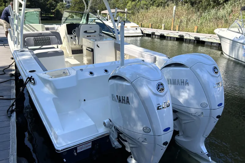 Slide: The Image of 2026 Cobia 280 Dual Console boat with twin Yamaha engines docked. - 2