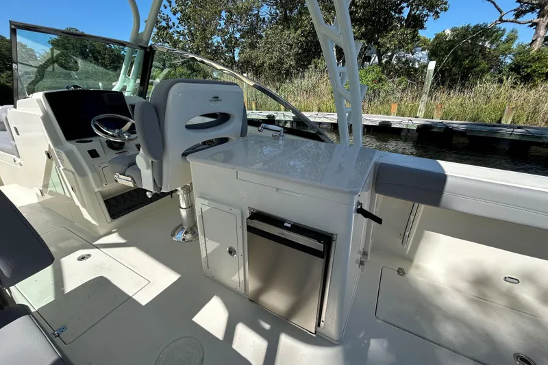 Slide: The Image of 2026 Cobia 280 Dual Console boat interior with helm, seating, and storage compartments. - 7