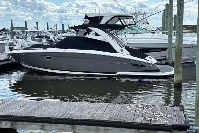 Slide: The Image of 2015 Regal 2800 Bowrider boat docked at marina, sleek design, calm water. - 1