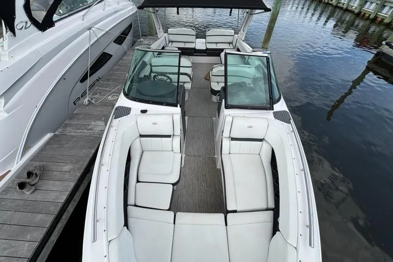 Slide: The Image of 2015 Regal 2800 Bowrider boat with spacious seating, docked by the water. - 12