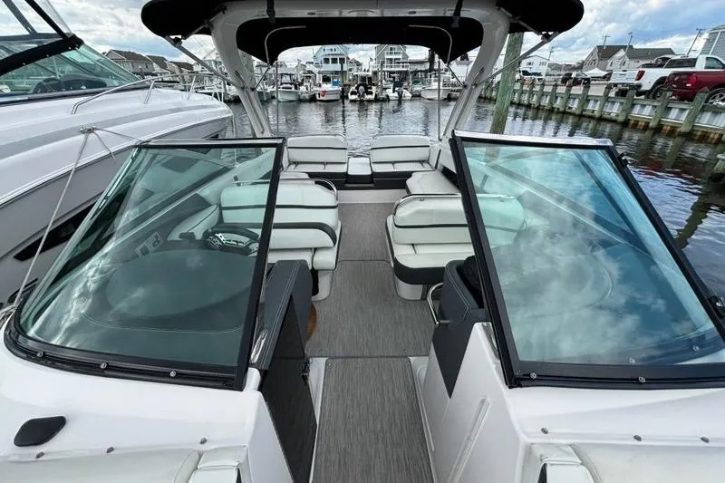 Slide: The Image of 2015 Regal 2800 Bowrider boat interior at marina, featuring spacious seating and sleek design. - 14