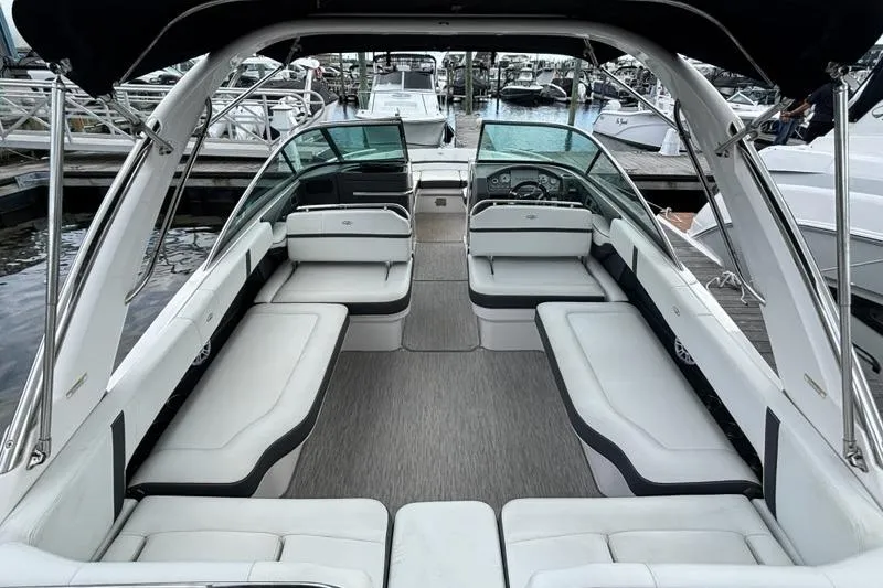 Slide: The Image of 2015 Regal 2800 Bowrider boat interior with spacious seating and sleek design at a marina. - 17