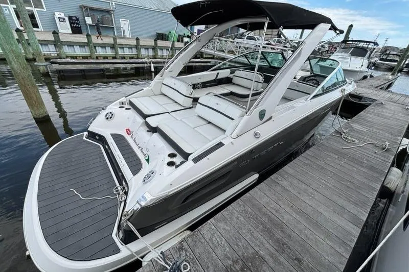Slide: The Image of 2015 Regal 2800 Bowrider docked, featuring sleek design and spacious seating. - 18