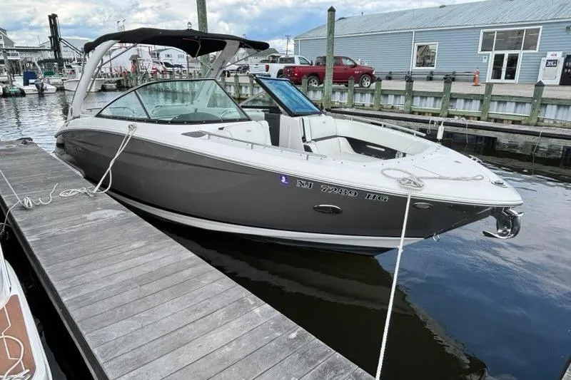 Slide: The Image of 2015 Regal 2800 Bowrider boat docked at marina, featuring sleek design and spacious seating. - 19