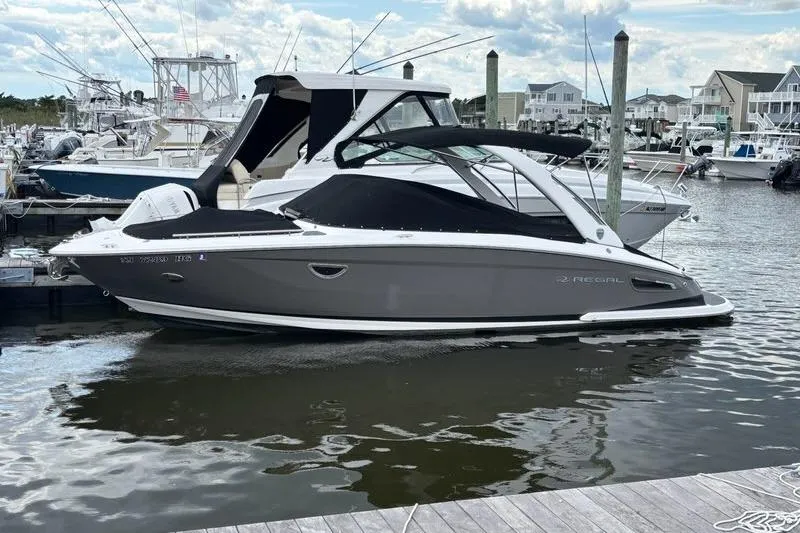 Slide: The Image of 2015 Regal 2800 Bowrider boat docked in a marina, featuring sleek design and modern amenities. - 2