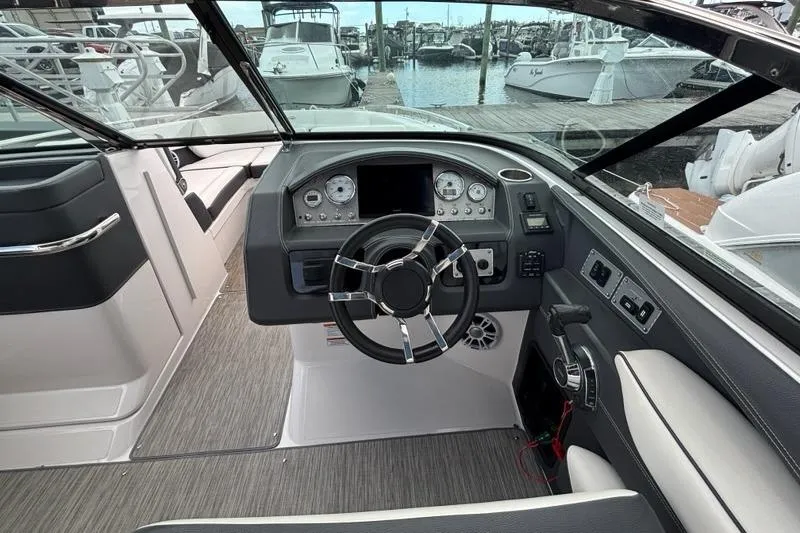 Slide: The Image of 2015 Regal 2800 Bowrider cockpit with steering wheel and dashboard, docked at marina. - 9