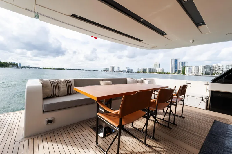 Slide: The Image of Luxurious Sanlorenzo SL96 yacht deck with dining area, overlooking waterfront cityscape, 2021 model. - 30