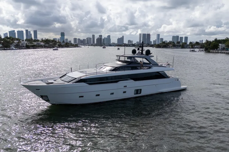 Slide: The Image of 2021 Sanlorenzo SL96 yacht cruising near a city skyline under cloudy skies. - 57