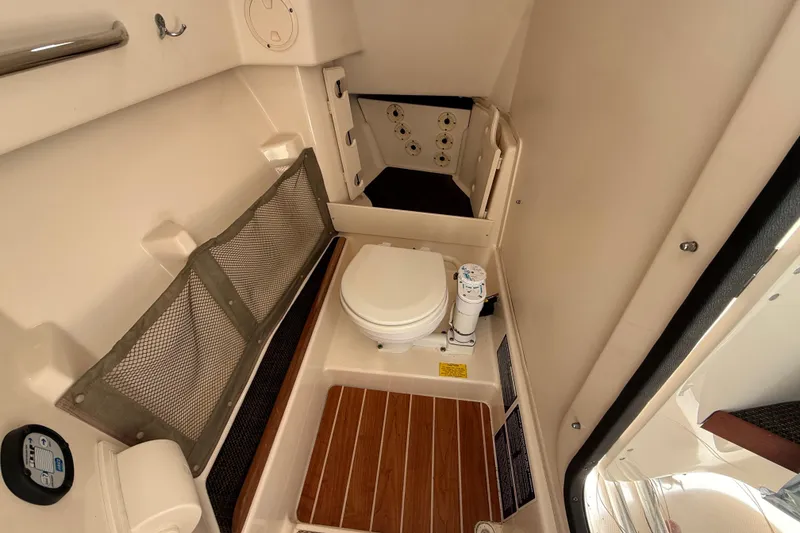 Slide: The Image of 2015 Grady-White Freedom 285 boat interior with compact marine toilet and storage. - 11