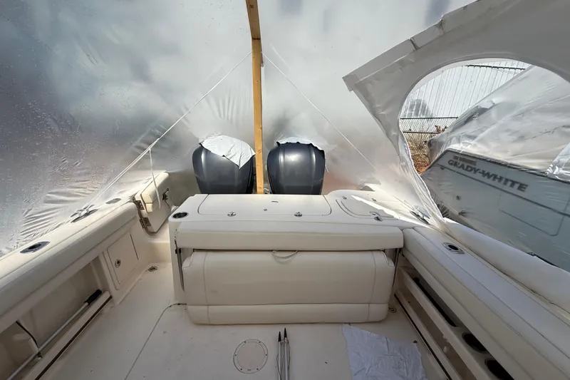 Slide: The Image of 2015 Grady-White Freedom 285 boat interior with twin engines under protective cover. - 18