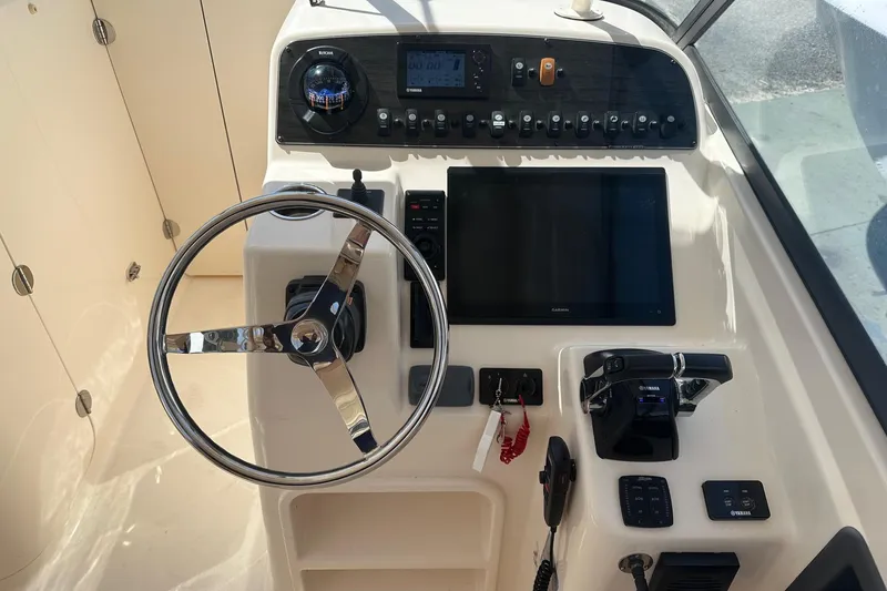 Slide: The Image of Helm of 2015 Grady-White Freedom 285 boat with steering wheel and control panel. - 2