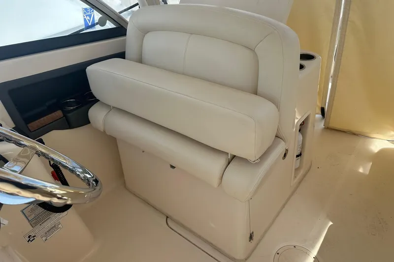 Slide: The Image of 2015 Grady-White Freedom 285 boat interior with beige seating and steering wheel. - 3