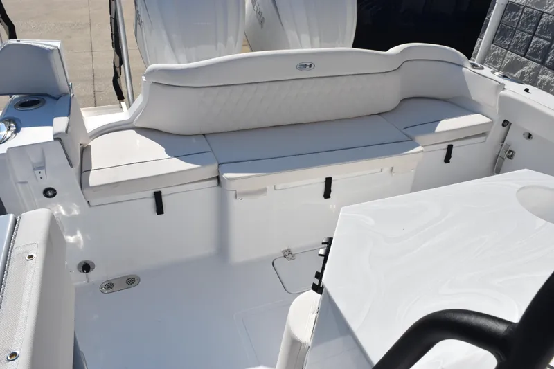 Slide: The Image of 2026 Sea Hunt Ultra 275 SE boat interior with white seating and storage compartments. - 11