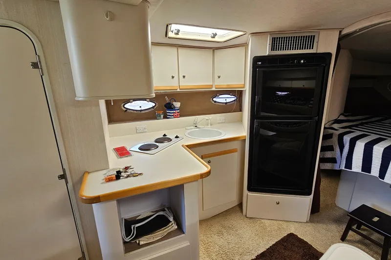 Slide: The Image of Interior of 1995 Cruisers Yachts 3775 Esprit, featuring kitchenette and cozy sleeping area. - 22