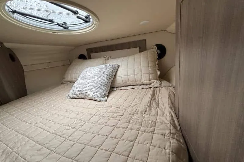 Slide: The Image of Cozy cabin interior of 2019 Regal 33 XO yacht with plush bedding and porthole. - 11