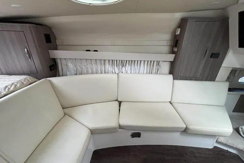 Slide: The Image of Interior of 2019 Regal 33 XO boat with white seating and wooden cabinets. - 12