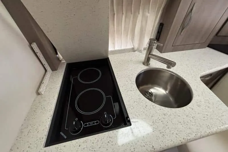 Slide: The Image of 2019 Regal 33 XO yacht kitchen with stovetop and round sink. - 16