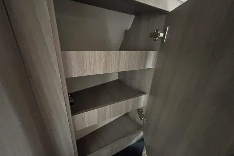 Slide: The Image of Interior shelving of 2019 Regal 33 XO boat, featuring wooden finish and open storage. - 18