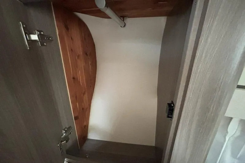 Slide: The Image of Interior view of a 2019 Regal 33 XO boat closet with wooden finish. - 20